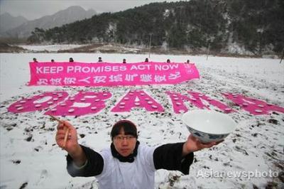Volunteer&nbsp;Xiao&nbsp;Xin&nbsp;holds&nbsp;a&nbsp;rice&nbsp;bowl&nbsp;and&nbsp;chopsticks&nbsp;while&nbsp;standing&nbsp;in&nbsp;front&nbsp;of&nbsp;a&nbsp;sign&nbsp;during&nbsp;a&nbsp;snowfall&nbsp;on&nbsp;the&nbsp;outskirts&nbsp;of&nbsp;Beijing&nbsp;November&nbsp;12,&nbsp;2009.&nbsp;The&nbsp;organizer&nbsp;Oxfam&nbsp;Hong&nbsp;Kong,&nbsp;an&nbsp;international&nbsp;NGO,&nbsp;held&nbsp;the&nbsp;activity&nbsp;to&nbsp;call&nbsp;on&nbsp;U.S.&nbsp;President&nbsp;Barack&nbsp;Obama,&nbsp;who&nbsp;will&nbsp;visit&nbsp;China&nbsp;next&nbsp;week,&nbsp;to&nbsp;keep&nbsp;his&nbsp;public&nbsp;promises&nbsp;and&nbsp;ensure&nbsp;that&nbsp;the&nbsp;U.S.&nbsp;plays&nbsp;a&nbsp;key&nbsp;leadership&nbsp;role&nbsp;in&nbsp;the&nbsp;climate&nbsp;negotiations&nbsp;culminating&nbsp;at&nbsp;the&nbsp;UN&nbsp;Climate&nbsp;Change&nbsp;Conference&nbsp;in&nbsp;Copenhagen&nbsp;in&nbsp;December.&nbsp;The&nbsp;Chinese&nbsp;characters&nbsp;on&nbsp;the&nbsp;banner&nbsp;reads&nbsp;"Against&nbsp;Climate&nbsp;Change&nbsp;for&nbsp;Poverty&nbsp;People".&nbsp;[Asianewsphoto]