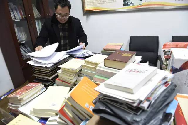 乐山市公路局工作人员在公路局原党委书记、交通局长王川的办公室整理书籍和文件（2月13日摄）。新华社记者 刘坤 摄