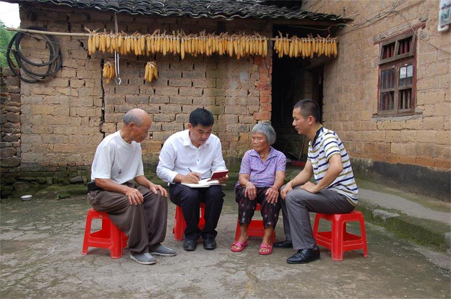 黄树新（左二）在北楼村文聚组贫困户中了解群众获得扶贫补助等情况。（图片来源：广西纪检监察网）