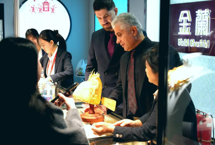 图为外宾观看中国非遗技艺制作的黄金饰品。