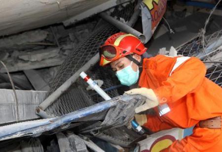 A member of China International Search and Rescue Team (CISAR) searches for survivors on debris near a destroyed supermarket in Port-au-Prince, Haiti, Jan. 19, 2010. The CISAR continued the rescue mission Tuesday in the city. (Xinhua/Yuan Man)