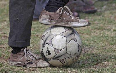 A child plays with a soccer ball at the launch of 'Football For Hope' in Alexandra Township north of Johannesburg, Thursday, March 25, 2010. The Football for Hope programme is a soccer tournament for underprivileged boys and girls from 32 countries that will run during the FIFA World Cup Soccer tournament(AP Photo/Denis Farrell)