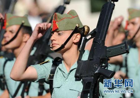 10月12日,一名西班牙女兵在马德里举行的国庆阅兵仪式中行进.