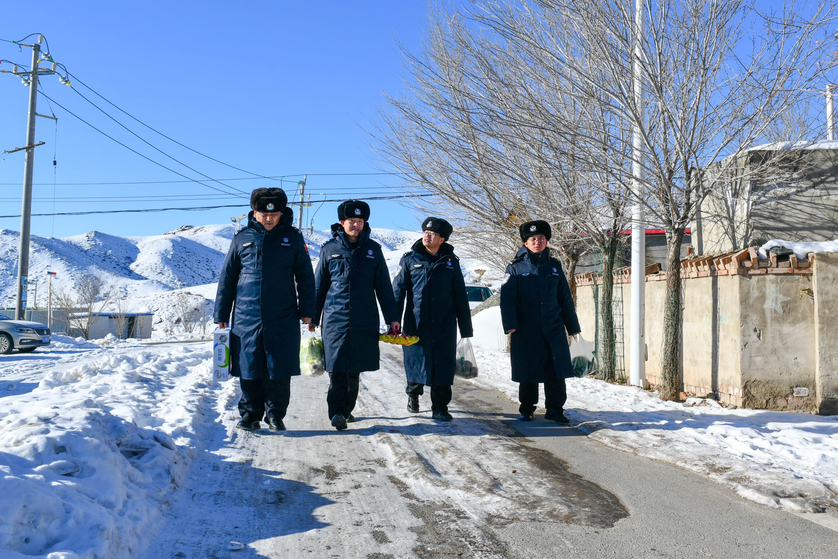 图为民警们携带生活物资区看望托乎提汗亚热