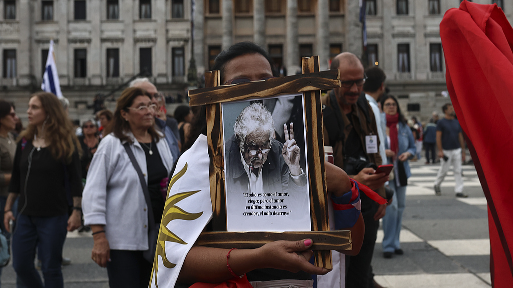 Supporters of former Uruguayan President Jose Mujica bid farewell as his coffin is carried out of the Legislative Palace in Montevideo, Uruguay, May 15, 2025. /VCG