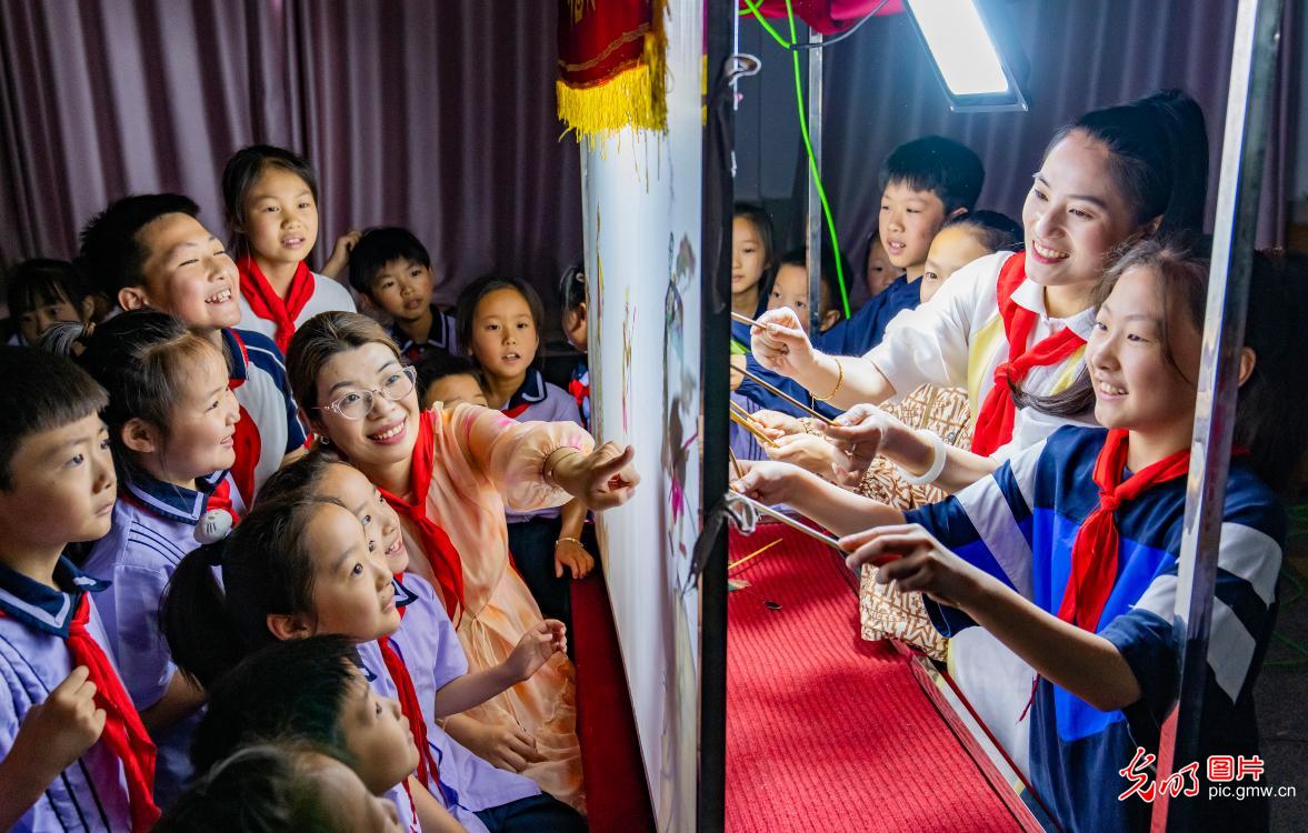 江苏省海安市教师发展中心附属小学开展“乐享皮影戏 快乐学非遗”主题活动。学生们通过制作皮影、观看皮影戏、体验皮影表演等形式,在寓教于乐中领悟传统文化的内涵和精髓,感受传统艺术的独特魅力。图为学生们在老师的指导下体验皮影戏表演。(翟伟凯摄/光明图片)