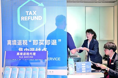 在广东深圳万象城离境退税“即买即退”集中退付点，工作人员为旅客办理现场退税。新华社发