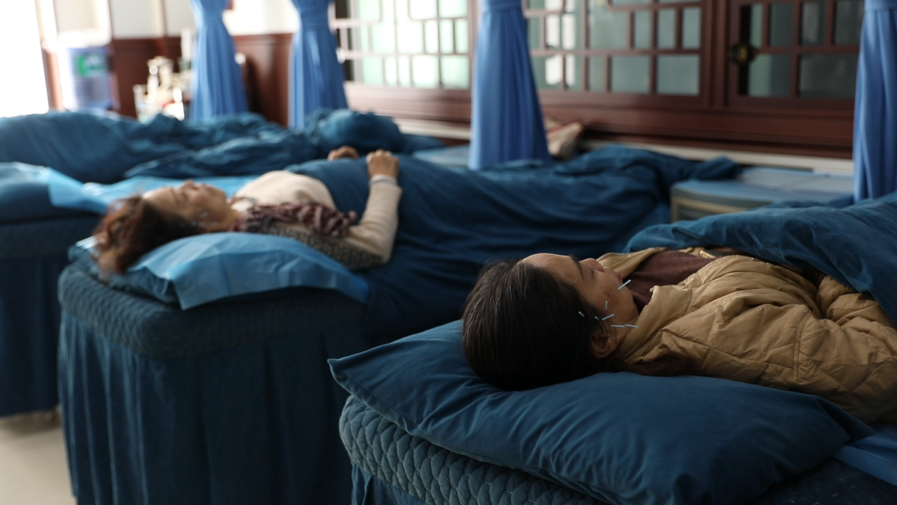 游客体验瑶医诊疗法（黄春华/摄）