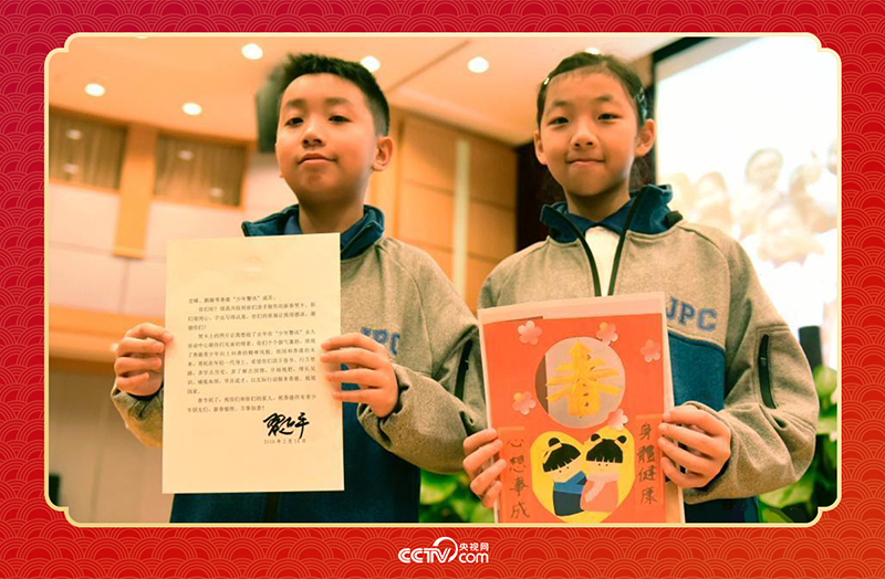 图为香港&ldquo;少年警讯&rdquo;成员郭宏晞（左）展示习主席回信、罗颢凝（右）展示送给习主席的贺卡并合影。