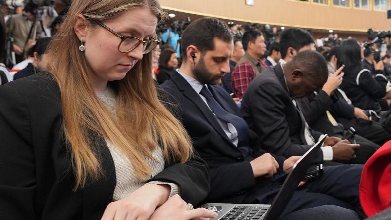 Journalists work at a press conference attended by Chinese Foreign Minister Wang Yi on the sidelines of the fourth session of the 14th National People
