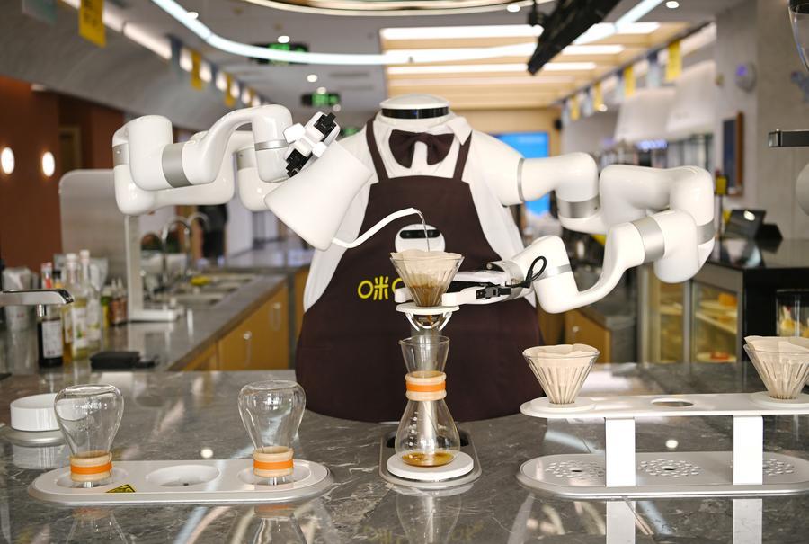 An AI robot makes coffee at a coffee shop in Xiong
