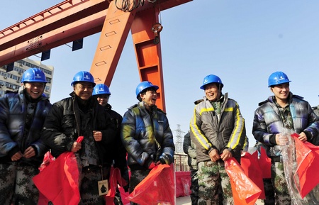 图为一线工人师傅们高兴的穿上刚刚送来的棉服