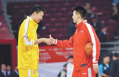 赛前,领衔南方明星队的王治郅(左)与北方明星队球员孙悦握手.新华社