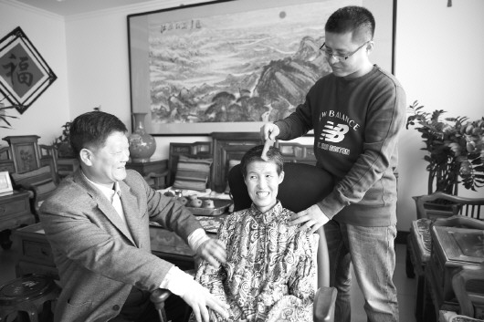 张更新在给妻子按摩,儿子在给妈妈梳头.